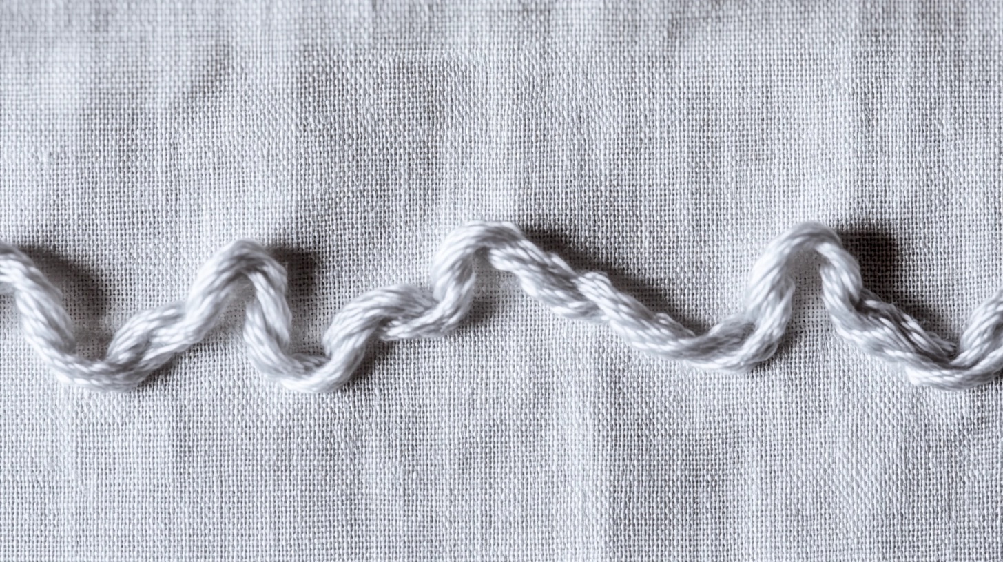 Several lazy daisy stitches forming flower petals on white fabric